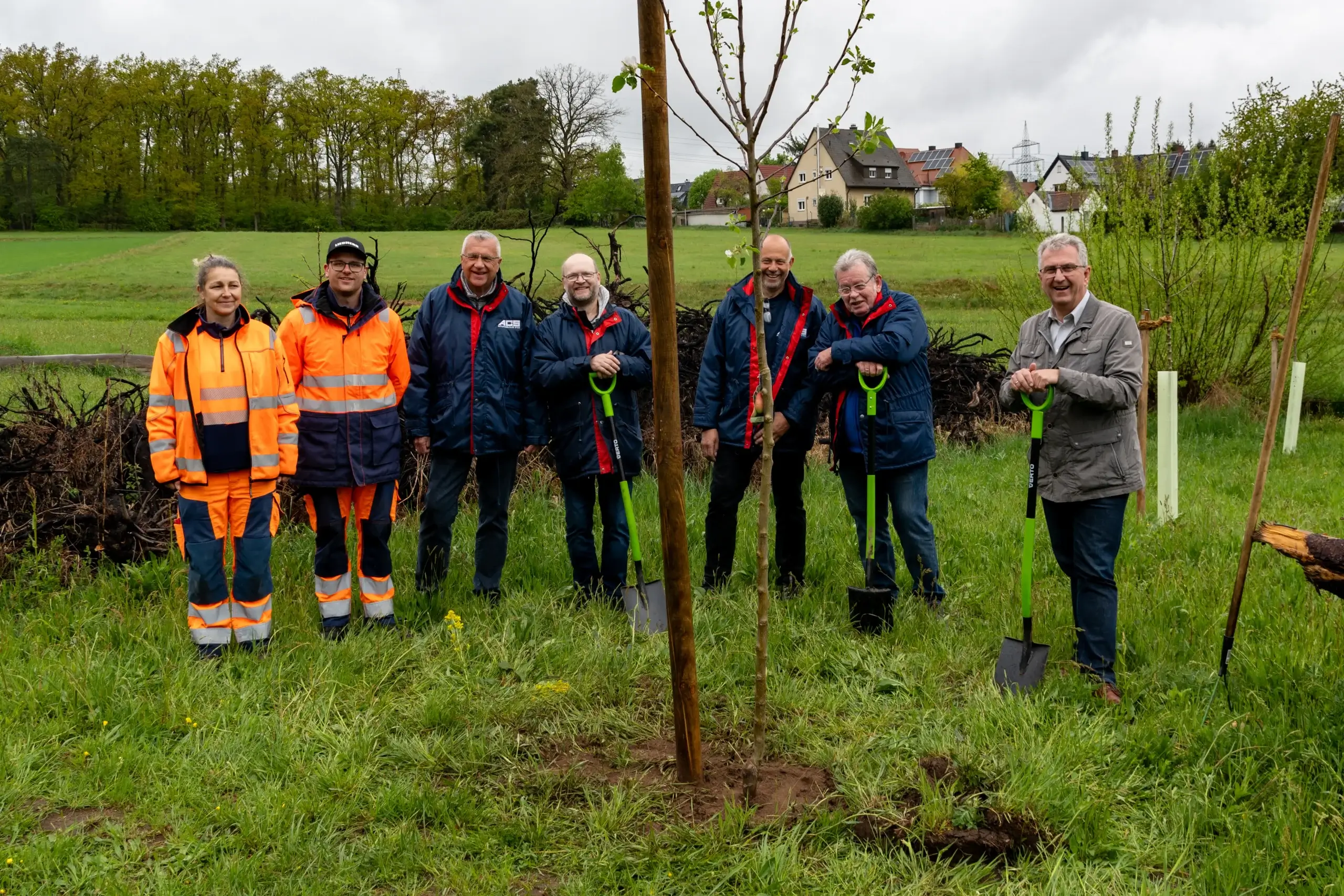 Mitarbeiter der Stadtgärtnerei und Mitglieder des Automobilclubs Stein pflanzen einen Apfelbaum im Beisein von Bürgermeister Kurt Krömer im Totholzgarten.