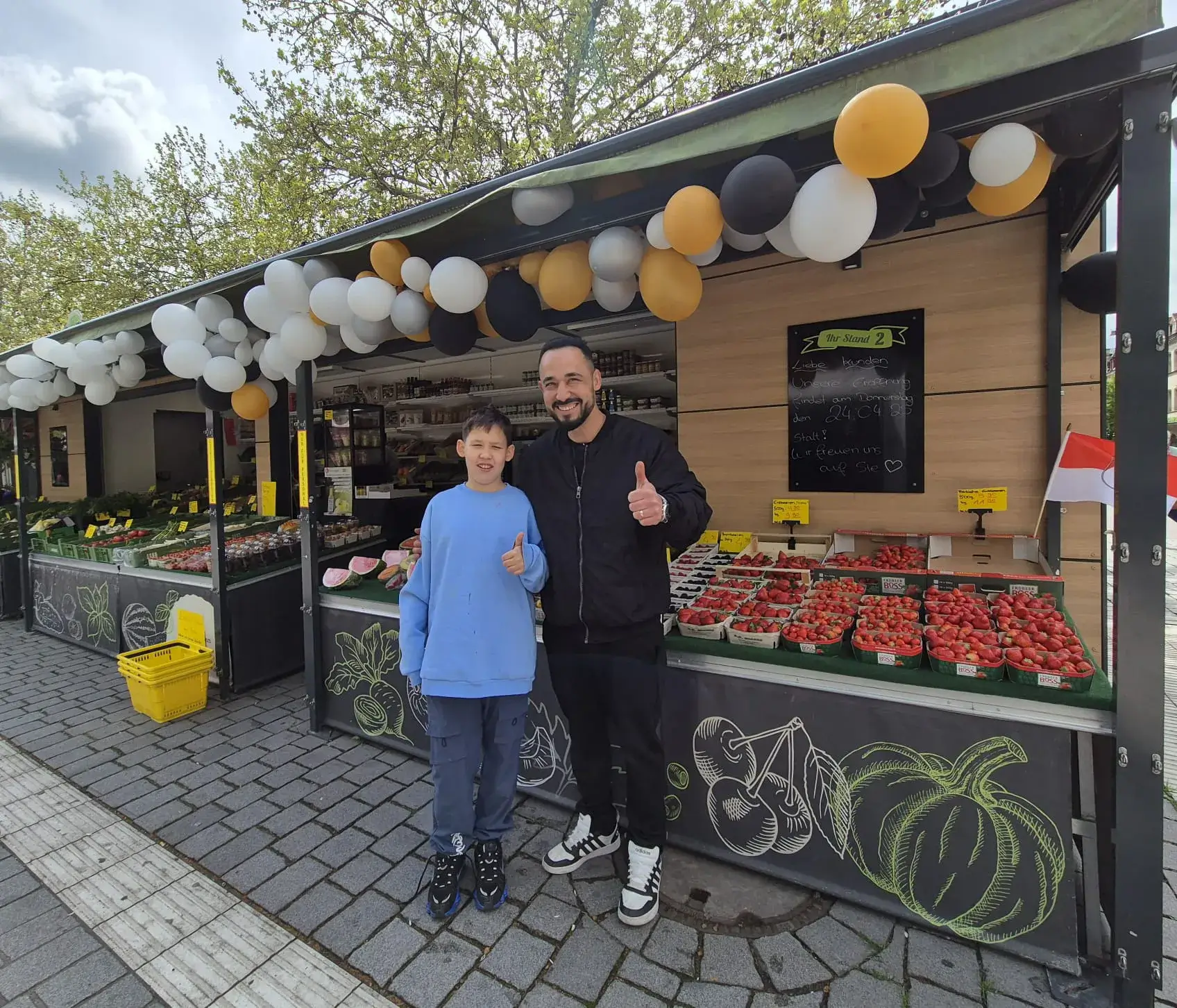 Volkan Kütük und sein Sohn vor ihrem neuen Obst- und Gemüsestand am Fürther Markt. Foto: Fürth Aktuell/Miriam Meingast